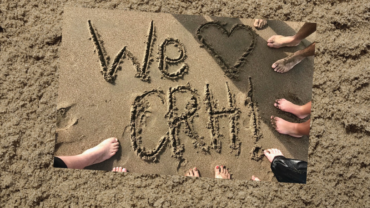 WE Love CRH written in sand with feet surrounding