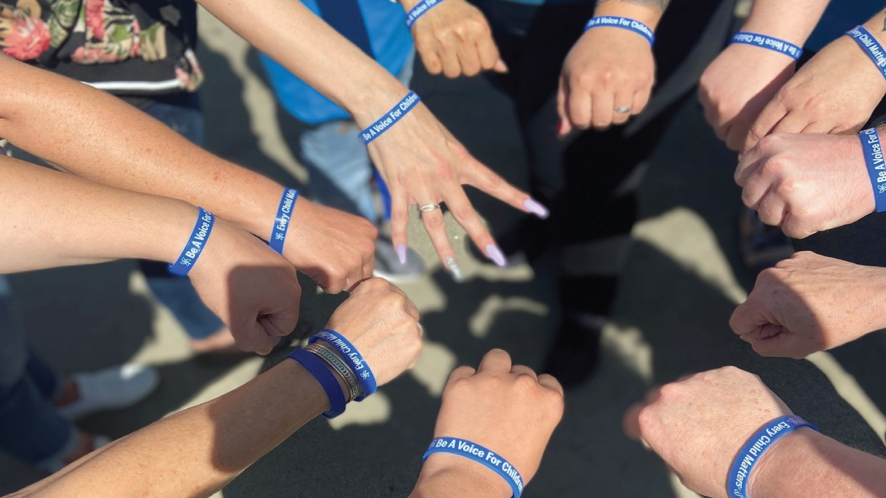 volunteers on a hands in wearing matching bracelets