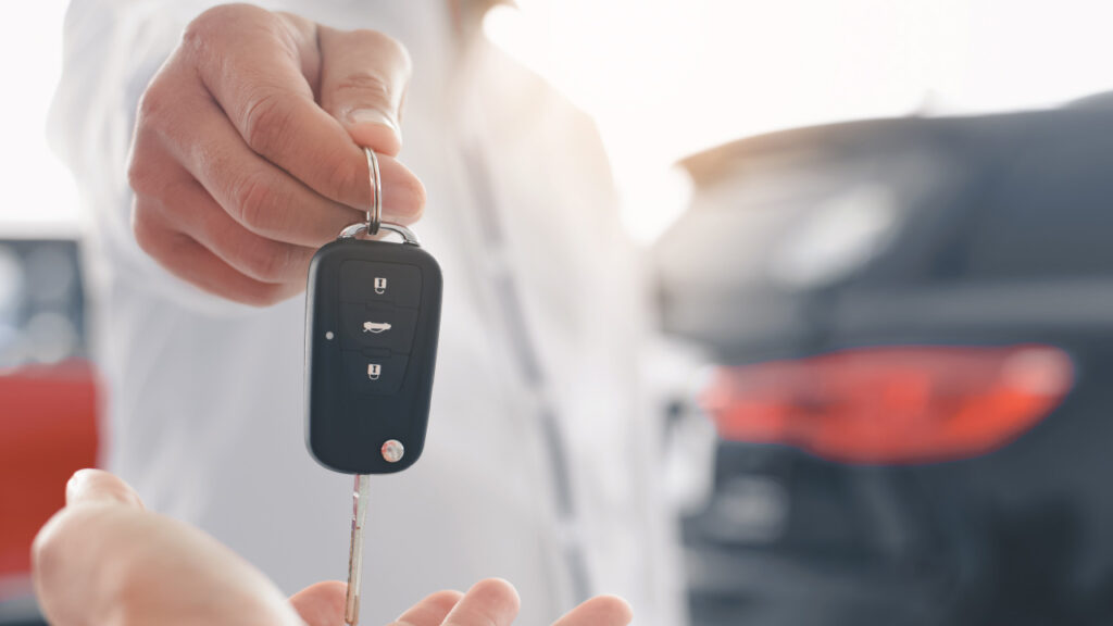 hand passing keys to car over to new owner